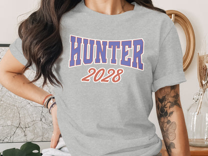 Grey t-shirt printed with "HUNTER 2028" in blue and red lettering.