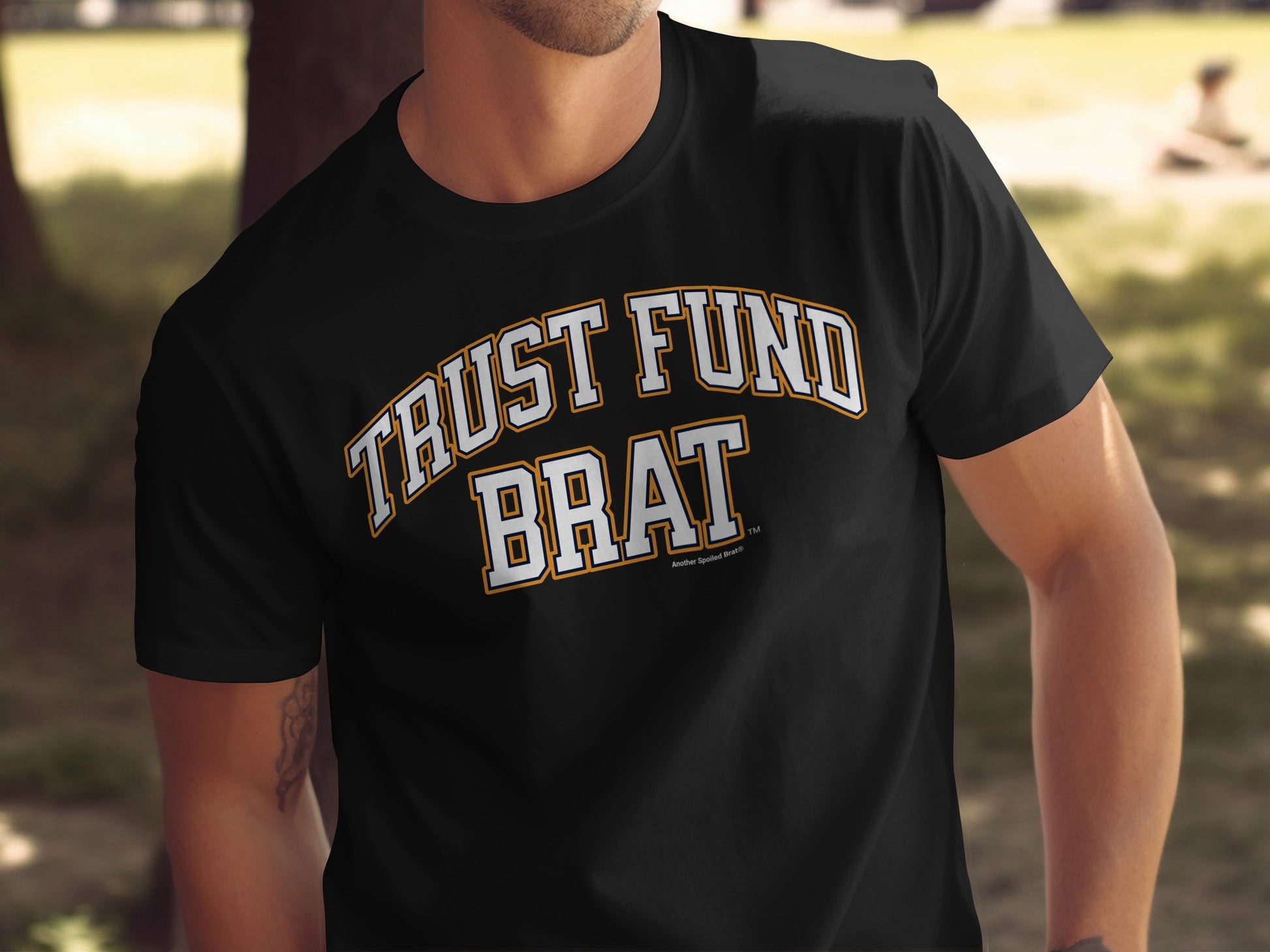 Black t-shirt with "TRUST FUND BRAT" text in white and orange lettering.