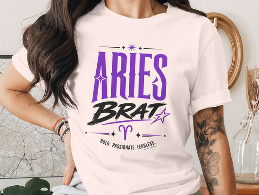 White t-shirt with "ARIES BRAT" in purple and black, featuring astrological symbols.