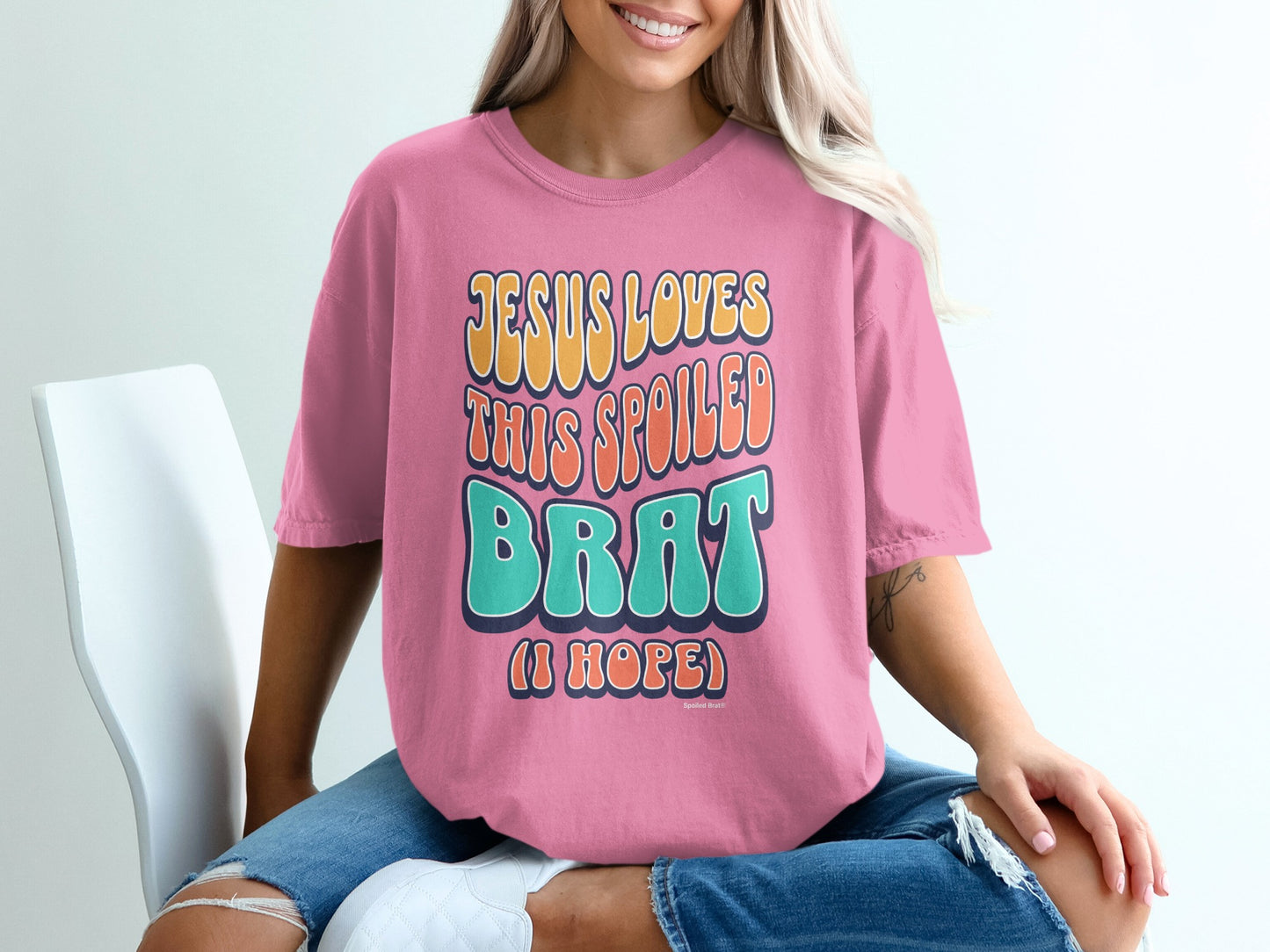 Pink t-shirt with "Jesus loves this spoiled brat (I hope)" text.