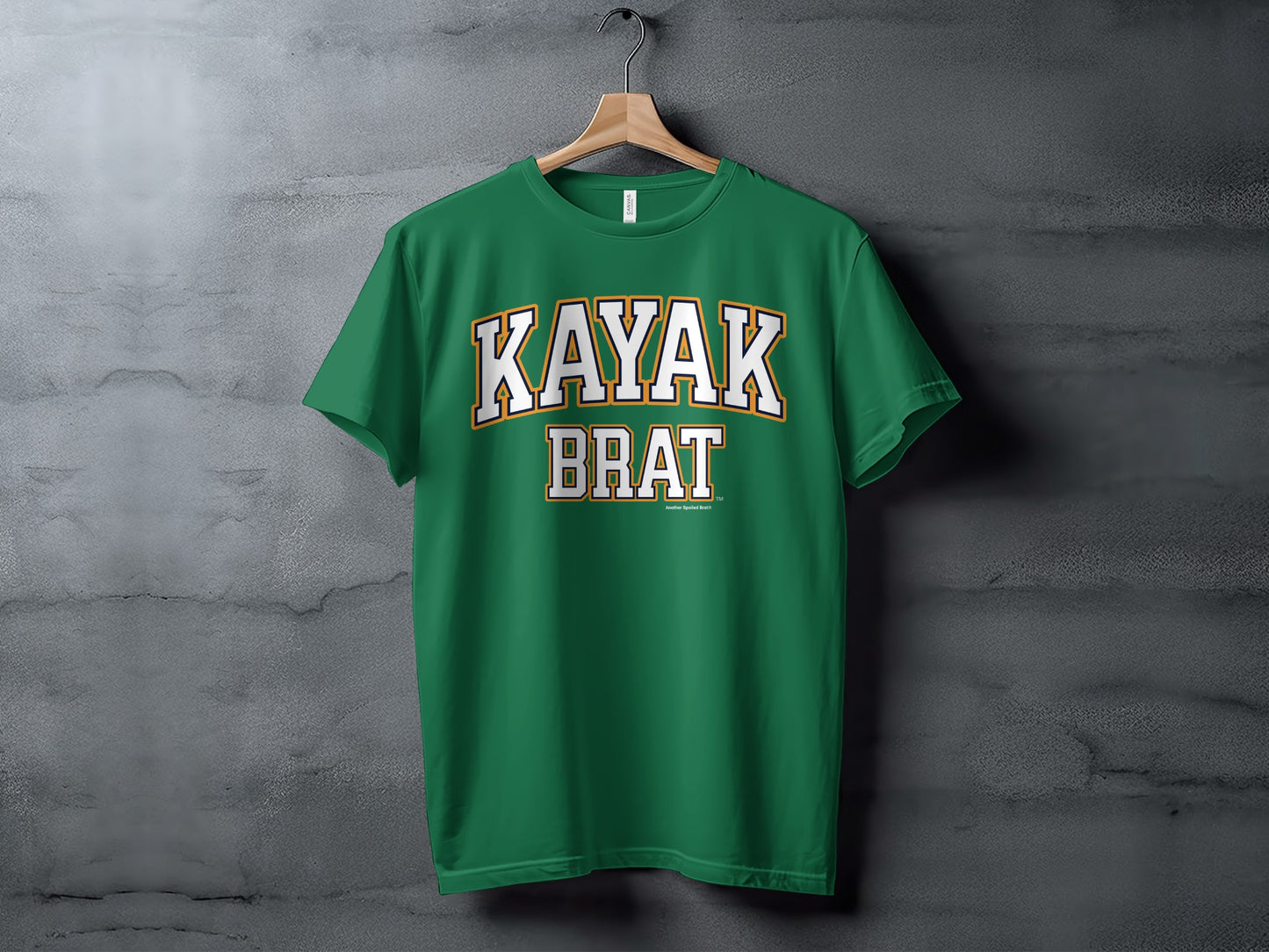 Green t-shirt with "KAYAK BRAT" text in white and yellow collegiate font.