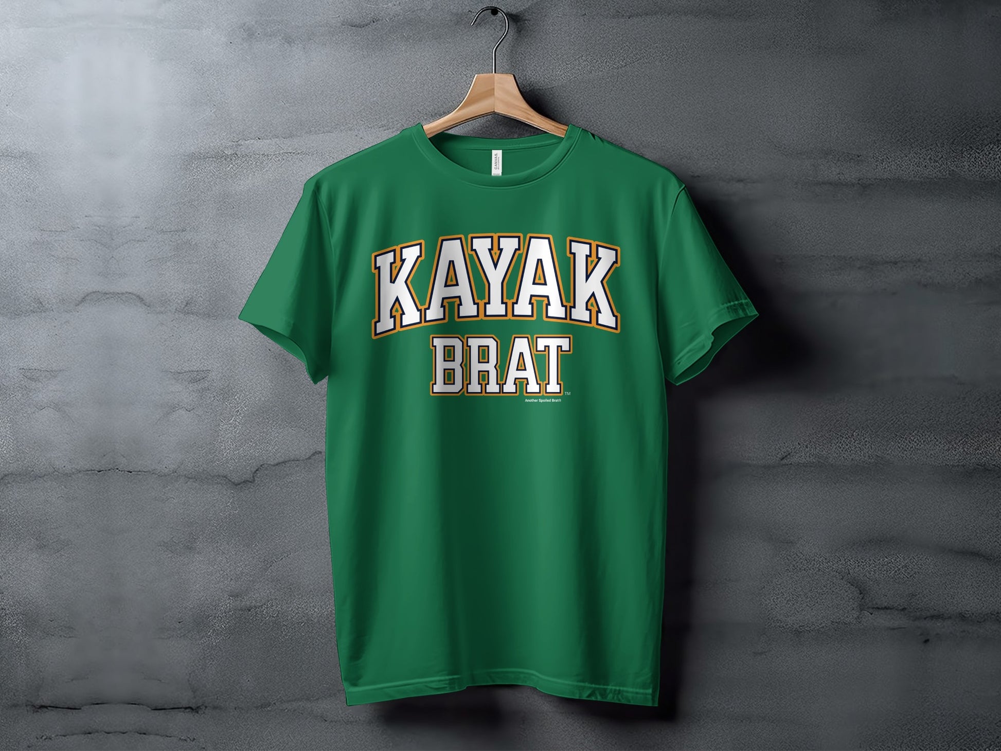 Green t-shirt with "KAYAK BRAT" text in white and yellow collegiate font.