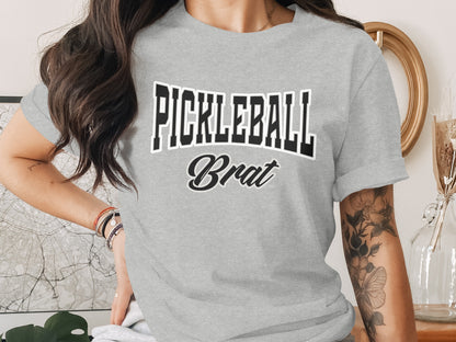Grey t-shirt with "PICKLEBALL Brat" text in black and white lettering.