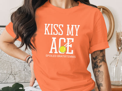 Orange t-shirt with "KISS MY ACE" and tennis ball graphic.