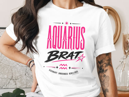 White t-shirt with "AQUARIUS BRAT" and "VISIONARY. UNBOUNDED. REBELLIOUS." text printed in pink and black.