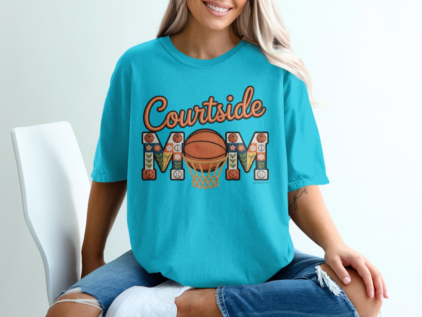 Turquoise t-shirt with "Courtside Mom" text, basketball, and net graphic.