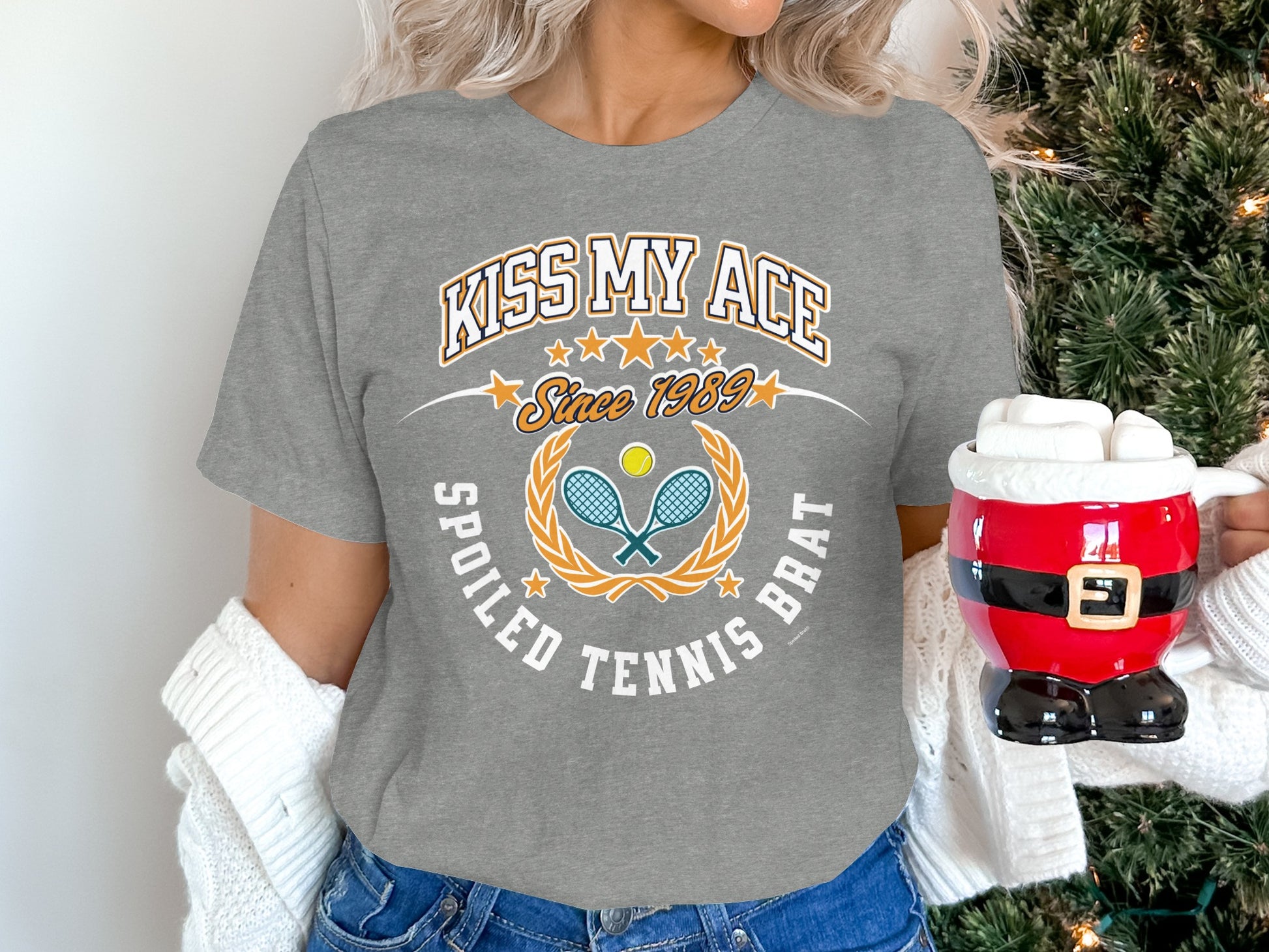 Grey t-shirt with "Kiss My Ace" and "Spoiled Tennis Brat" text and tennis graphics.