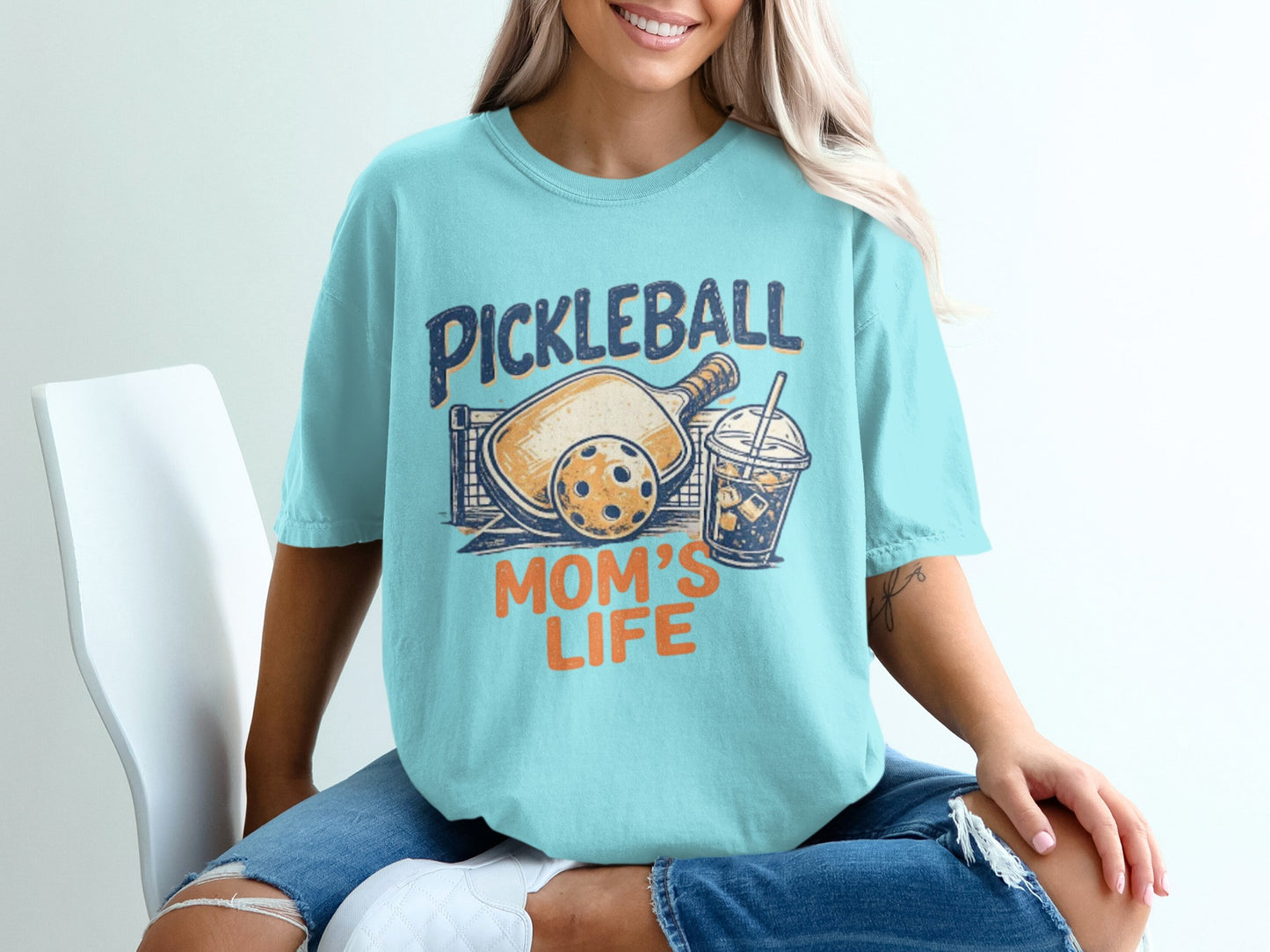 Blue t-shirt with "Pickleball Mom's Life" text, paddle, ball, and drink graphic.