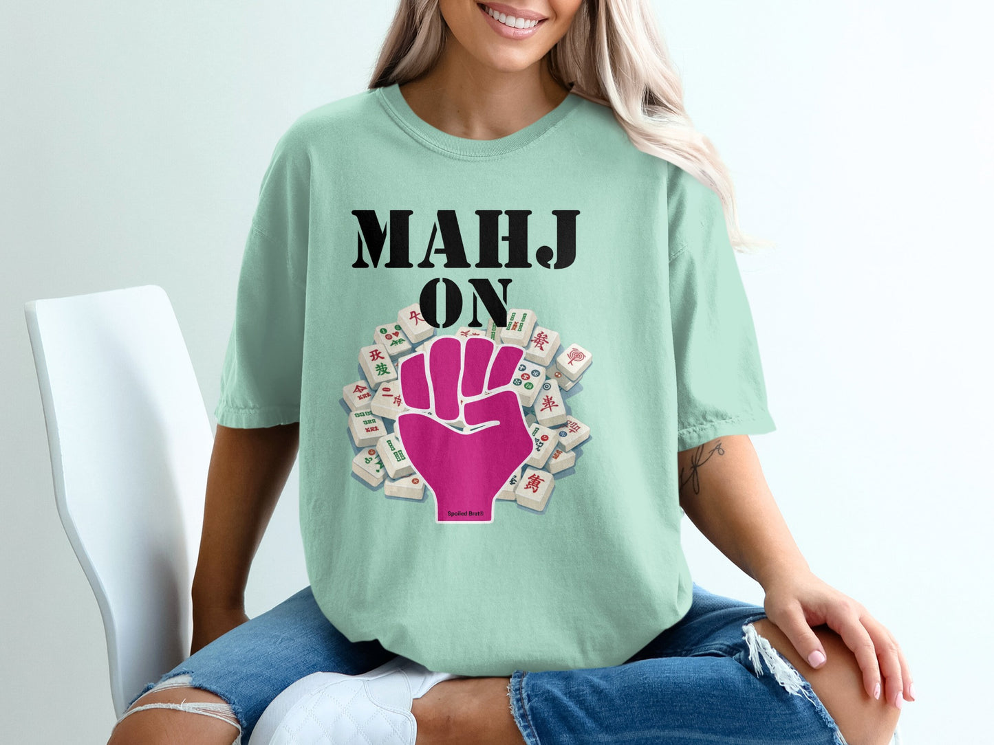 Light teal t-shirt with "MAHJ ON" and a pink mahjong tile hand.