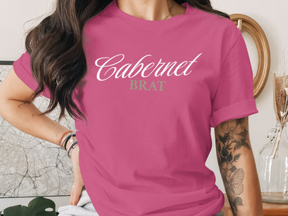 Pink t-shirt with white "Cabernet" and grey "Brat" text.