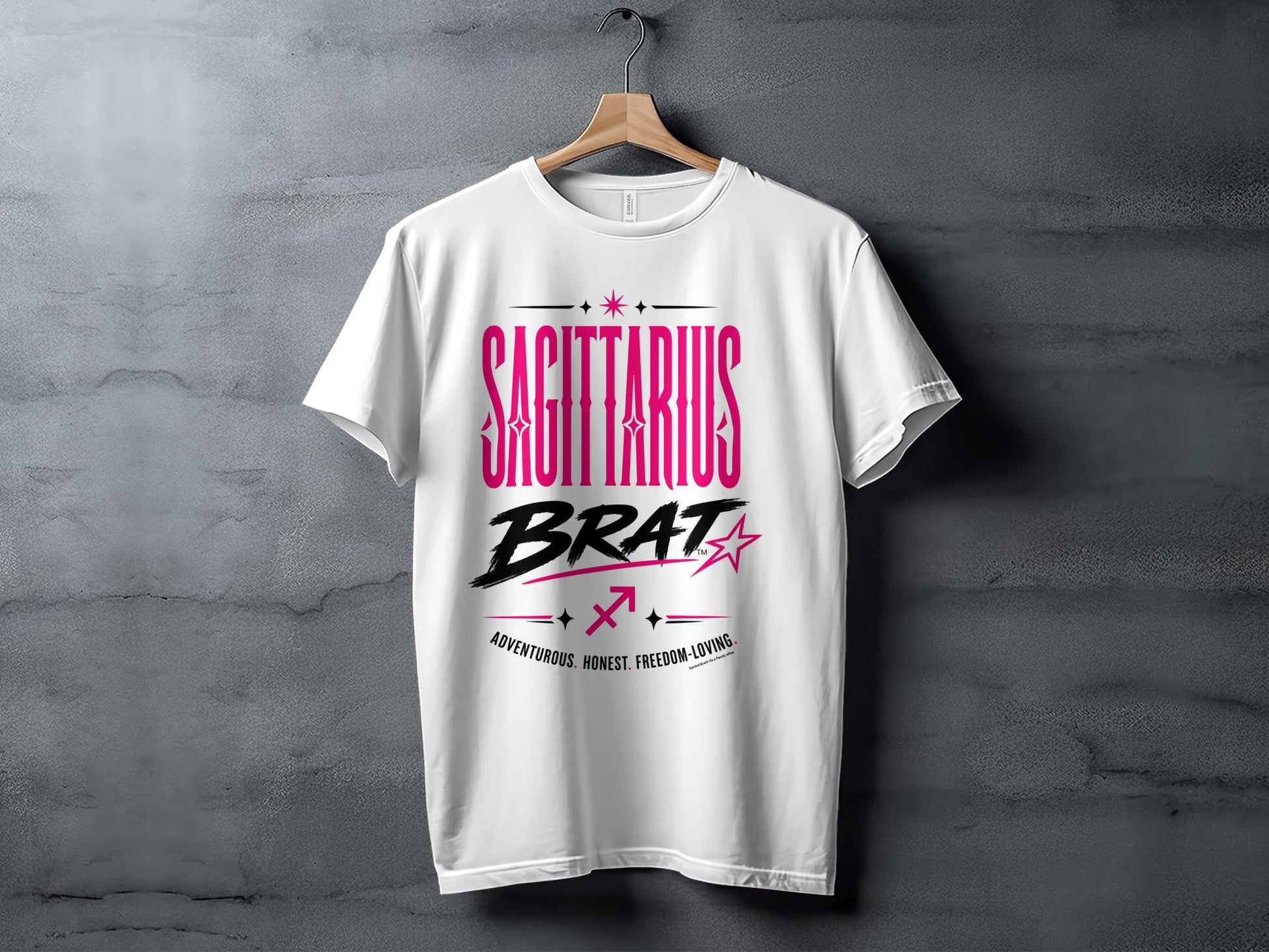 White t-shirt with pink text "SAGITTARIUS BRAT", zodiac symbol, and characteristics.