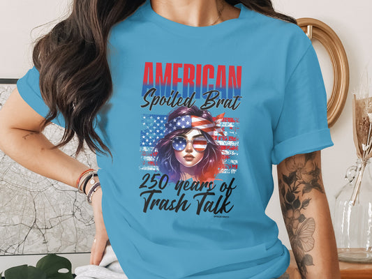 T-shirt with American flag graphic, sunglasses, and text "AMERICAN SPOILED BRAT".