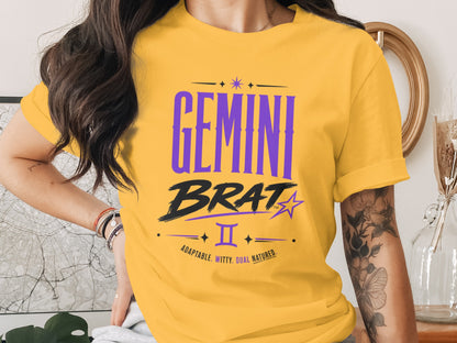 Yellow t-shirt with "GEMINI BRAT" text, Gemini symbol, and descriptive words.