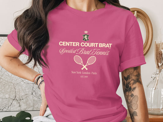 Pink t-shirt with "CENTER COURT BRAT Spoiled Brat Tennis" graphic and tennis rackets.