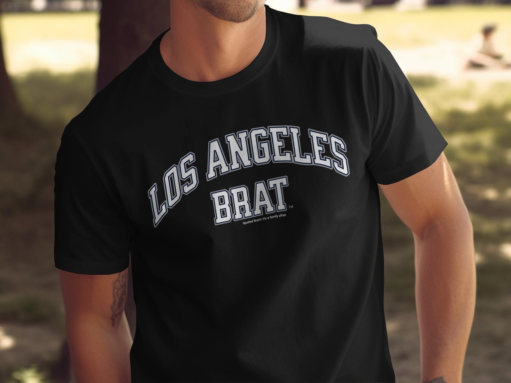 Black t-shirt with "LOS ANGELES BRAT" text in white arched lettering.