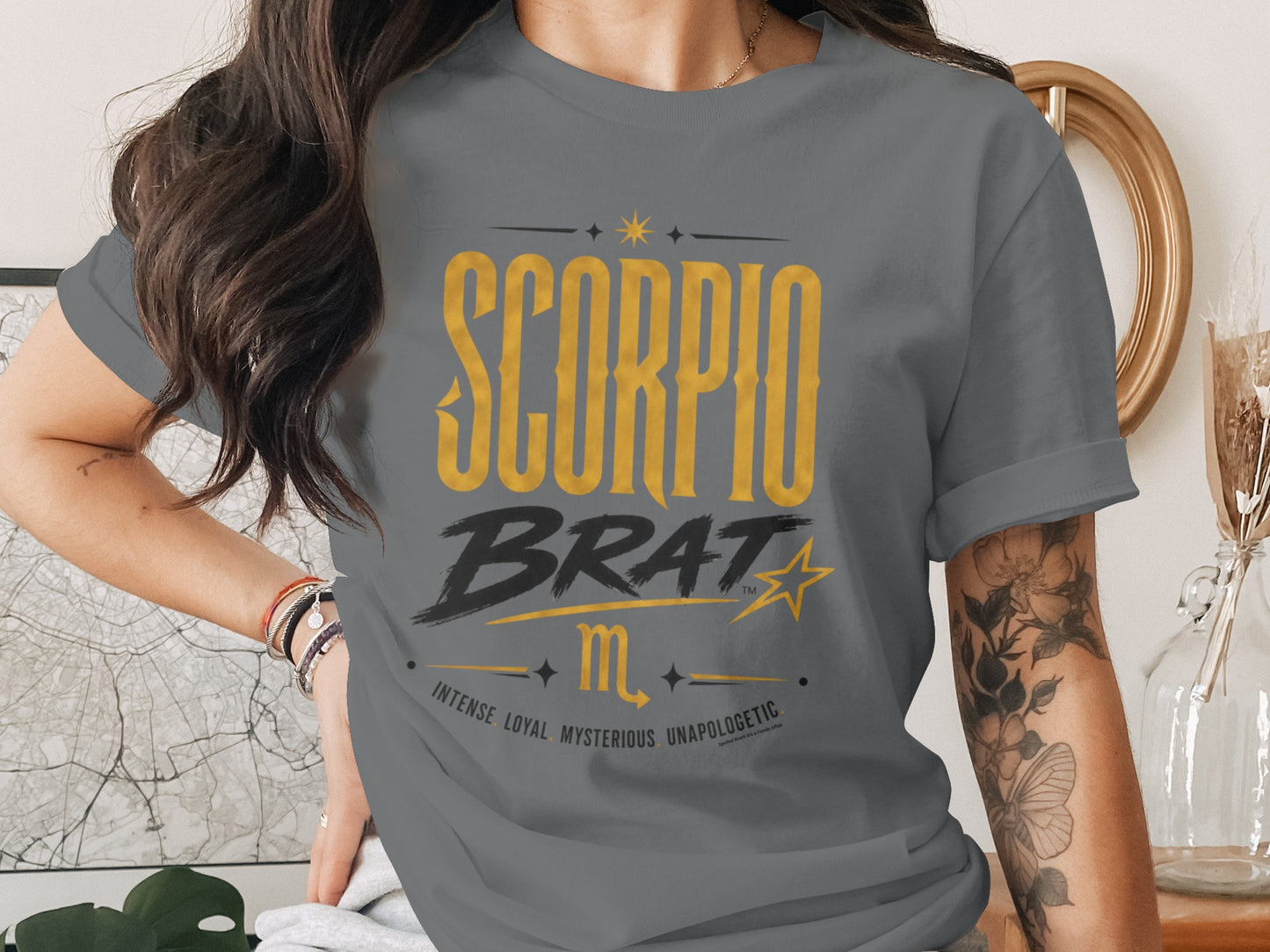 Scorpio Brat graphic tee with constellation and astrological traits on a grey t-shirt.