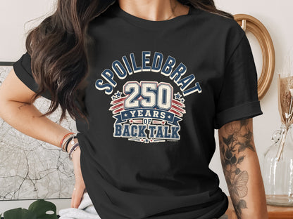 Black t-shirt with "SPOILED BRAT 250 YEARS OF BACK TALK" graphic.