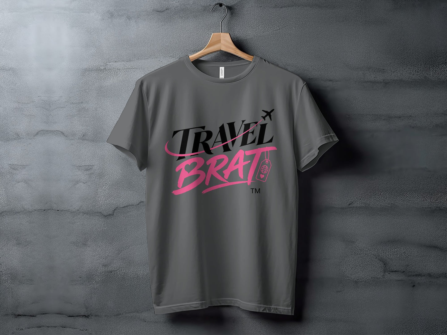 Gray t-shirt with the text "TRAVEL BRAT" in black and pink script.