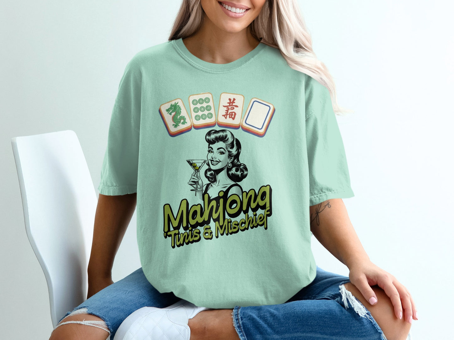 Light green t-shirt with vintage woman playing Mahjong graphic and text.