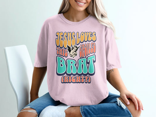 Pink t-shirt with "JESUS LOVES THIS BRAT (RIGHT?)" graphic.