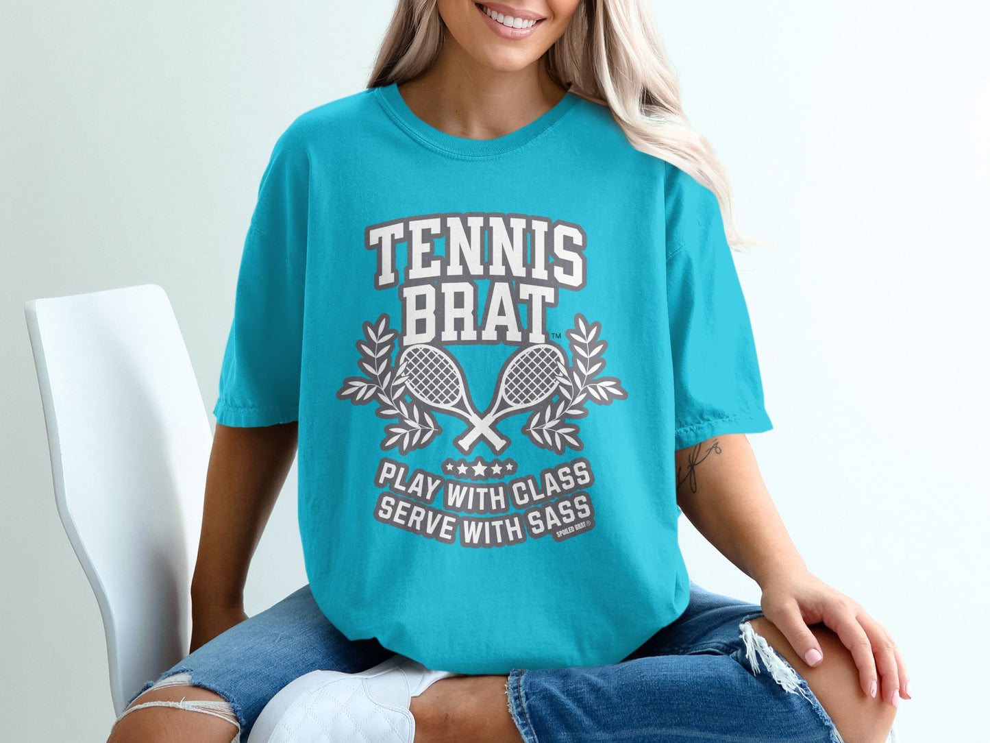 Turquoise t-shirt with "TENNIS BRAT PLAY WITH CLASS SERVE WITH SASS" and crossed rackets.