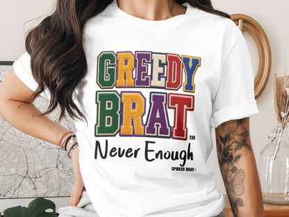 White t-shirt with "GREEDY BRAT" text and "Never Enough" slogan.