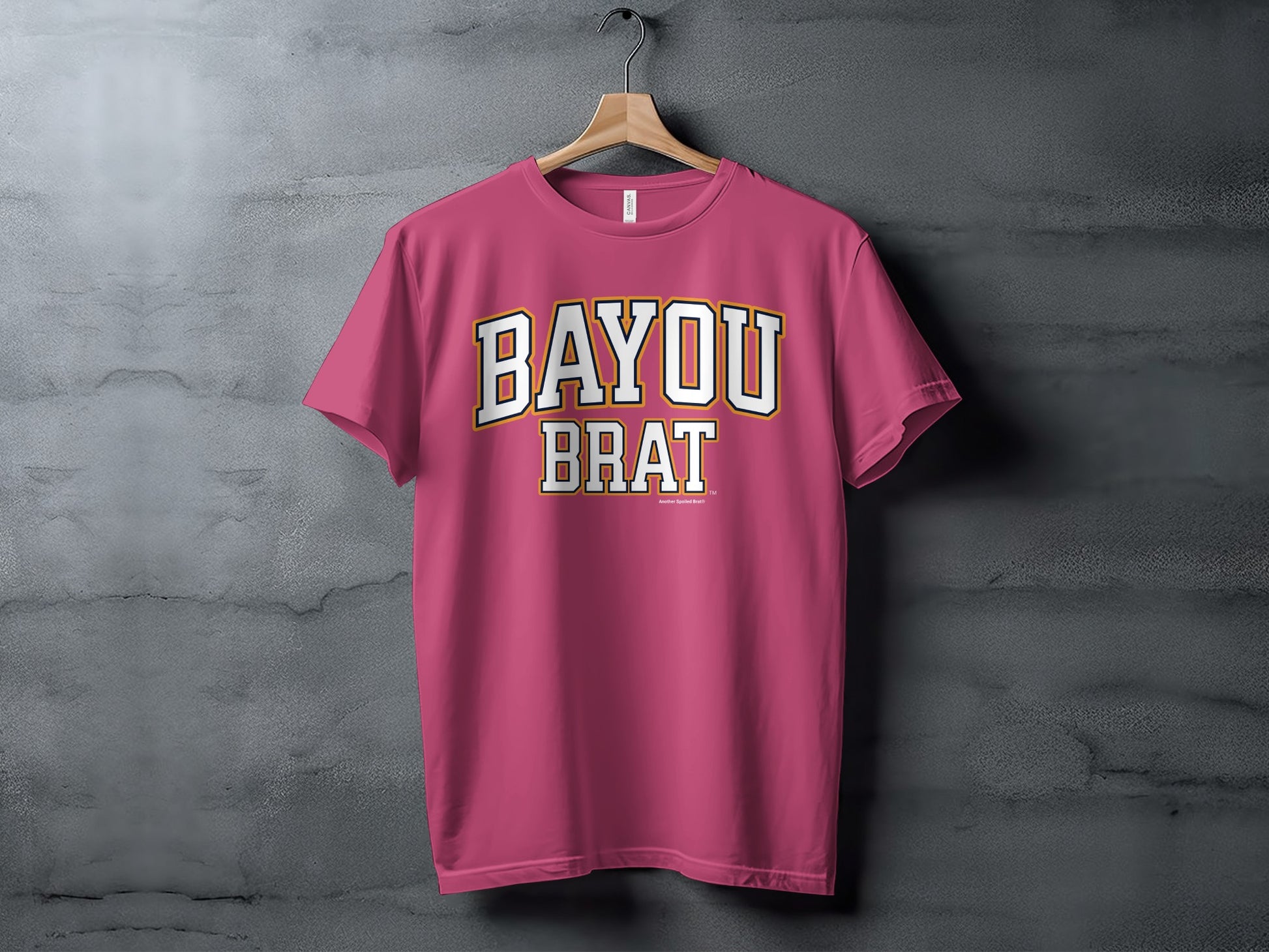 Pink t-shirt with "BAYOU BRAT" written in white and yellow block letters.