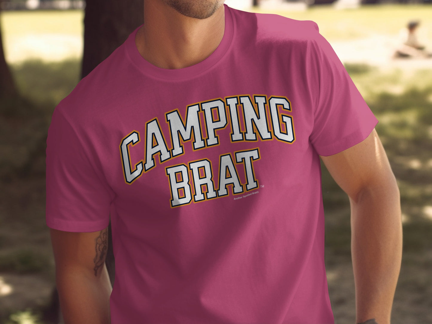 Pink t-shirt with white and gold text reading "CAMPING BRAT"