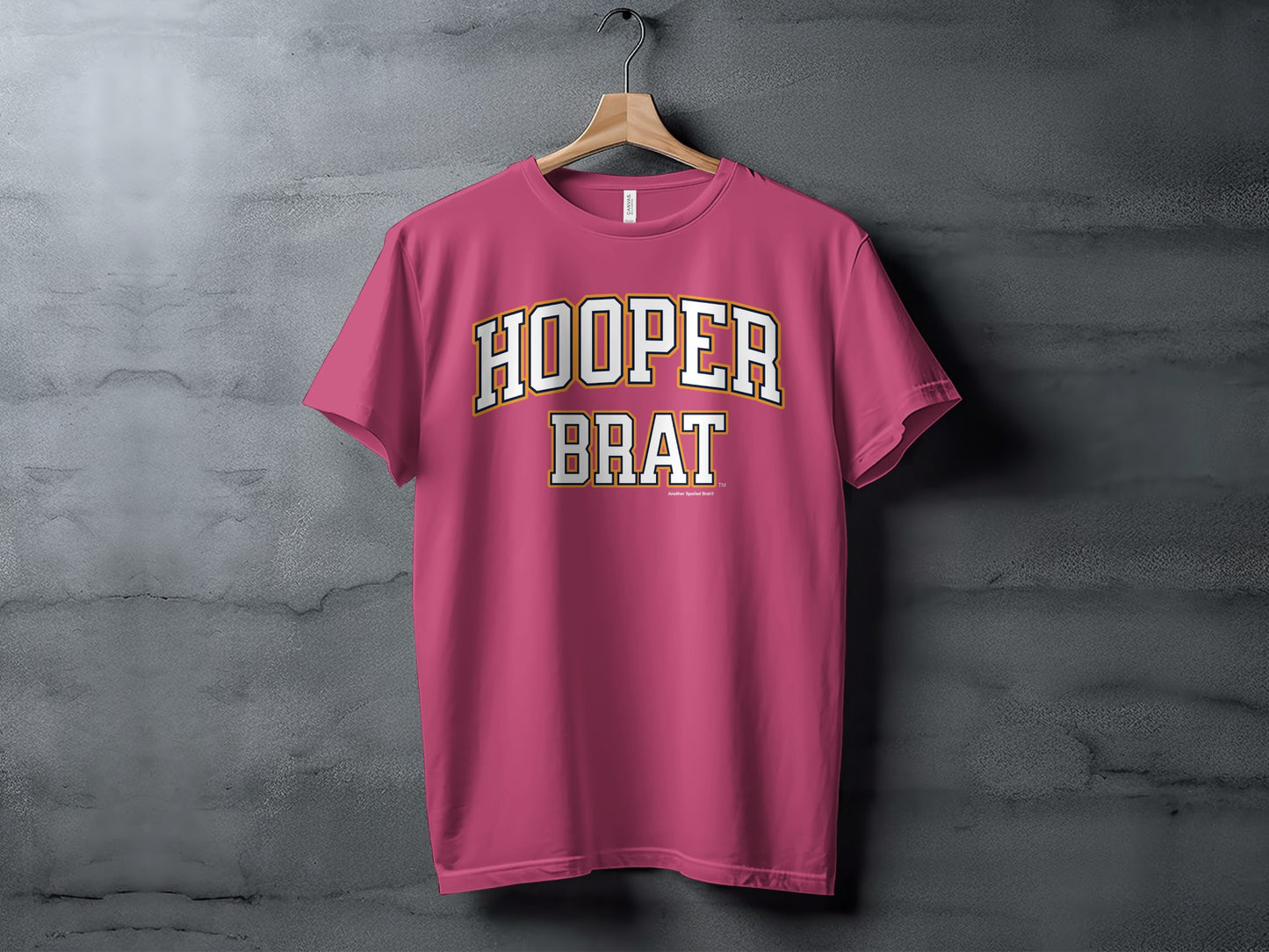 Pink t-shirt with white and orange text reading "HOOPER BRAT".