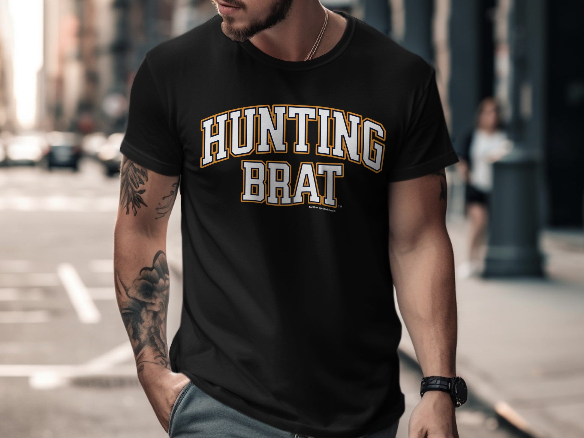 Black t-shirt with "HUNTING BRAT" in white and orange varsity lettering.