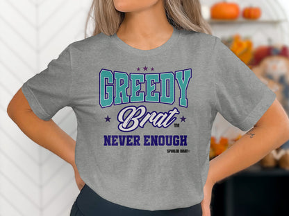 Grey t-shirt with "GREEDY Brat NEVER ENOUGH SPOILED BRAT®" text.