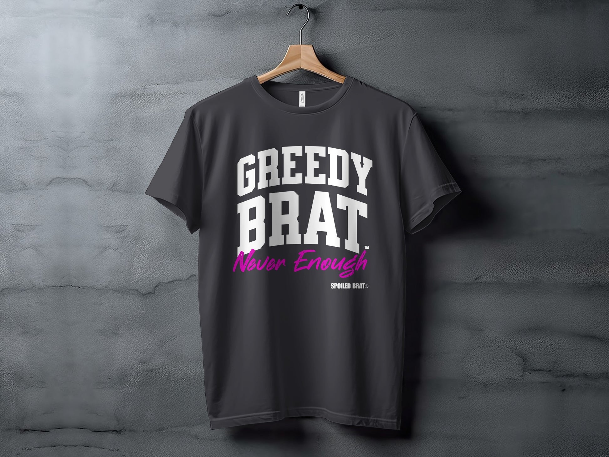 Dark grey t-shirt with "GREEDY BRAT" and "Never Enough" text in white and magenta.