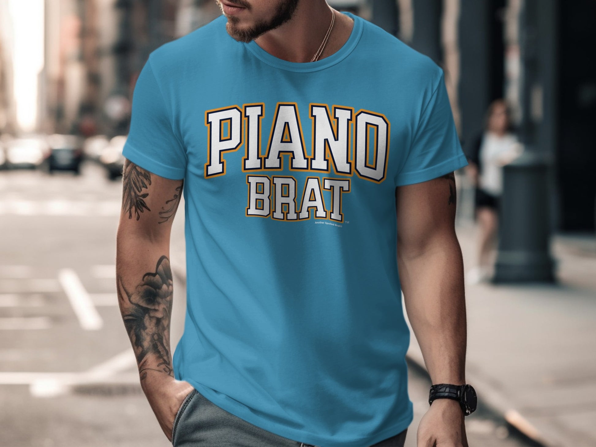 Blue t-shirt with "PIANO BRAT" text in collegiate font and distressed background.