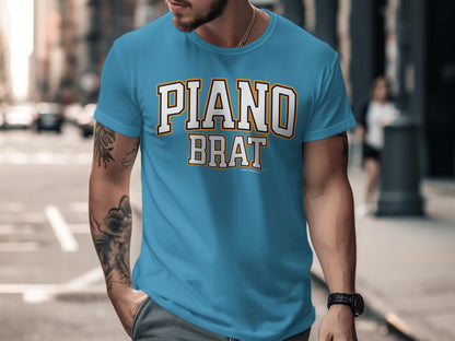 Blue t-shirt with "PIANO BRAT" text in collegiate font and distressed background.