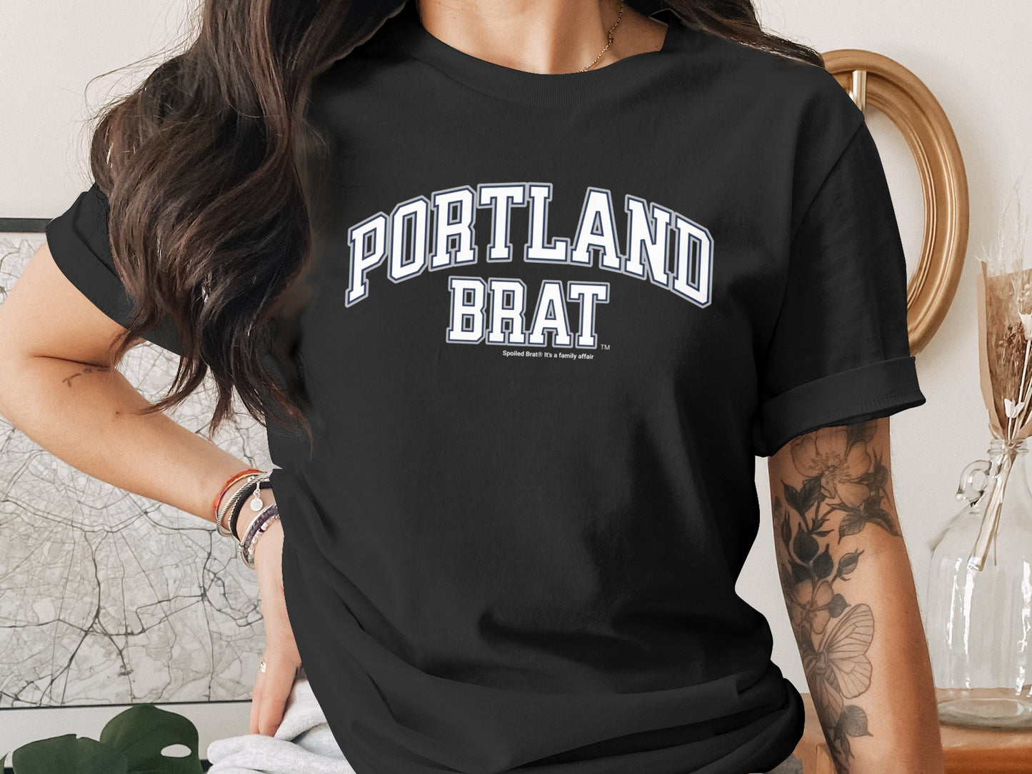Black t-shirt with "PORTLAND BRAT" in white collegiate font.