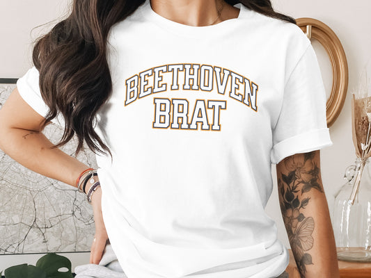 White t-shirt with "BEETHOVEN BRAT" arched text in yellow and navy blue.