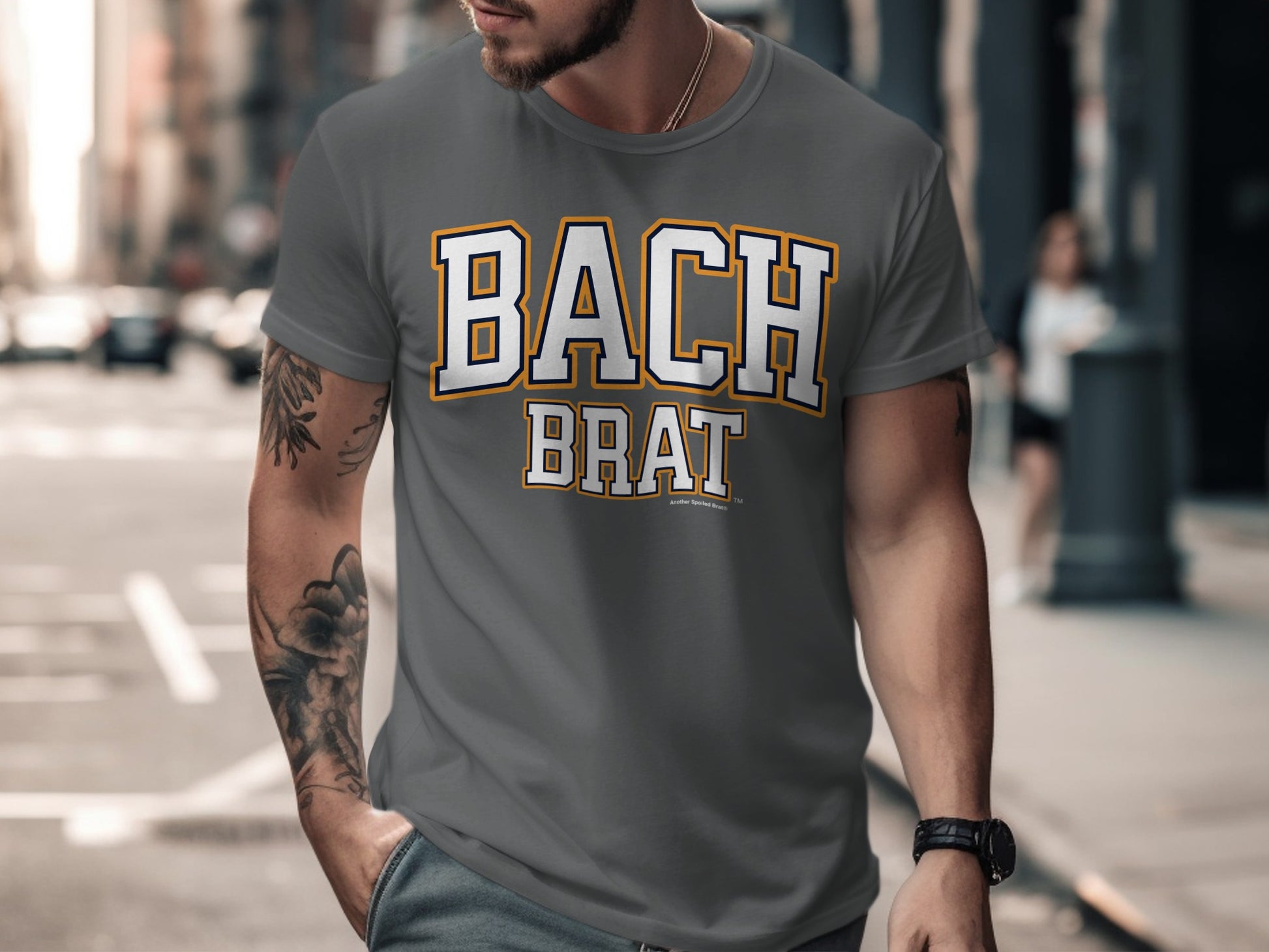 Grey t-shirt with bold white and yellow "BACH BRAT" text