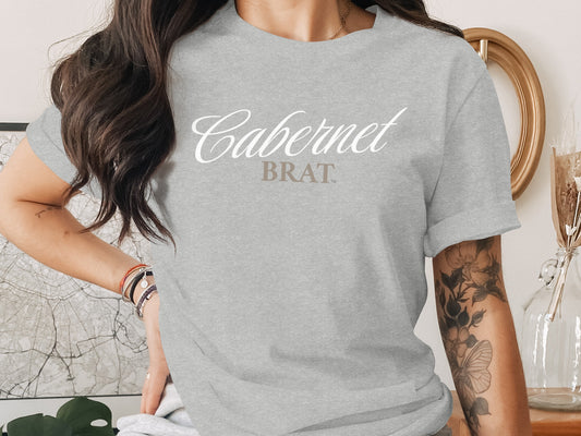 Grey t-shirt with "Cabernet BRAT" text, woman wearing a bracelet.