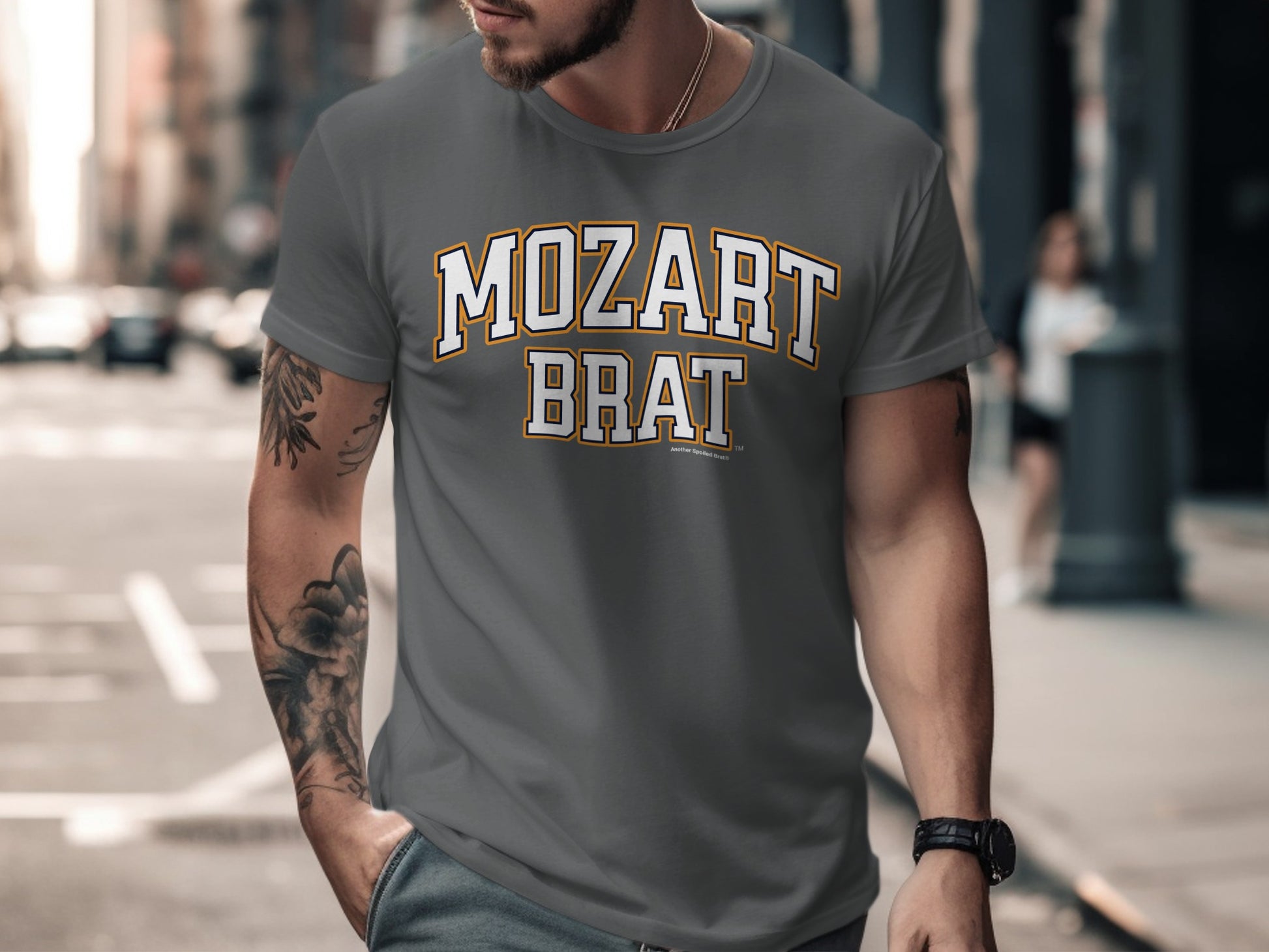 Grey t-shirt features white and gold text reading "MOZART BRAT".