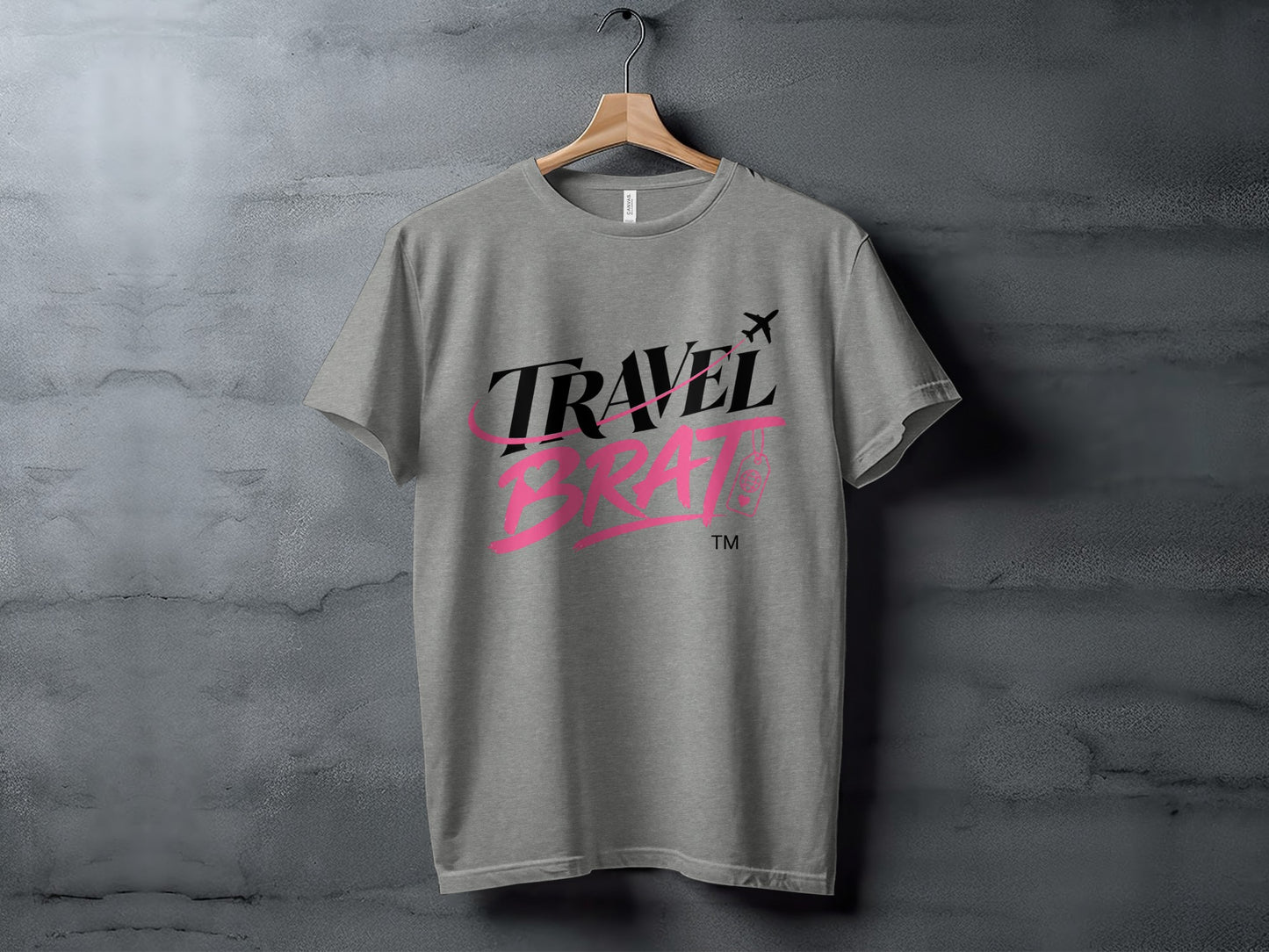 Grey t-shirt with "TRAVEL BRAT" text and airplane graphic.