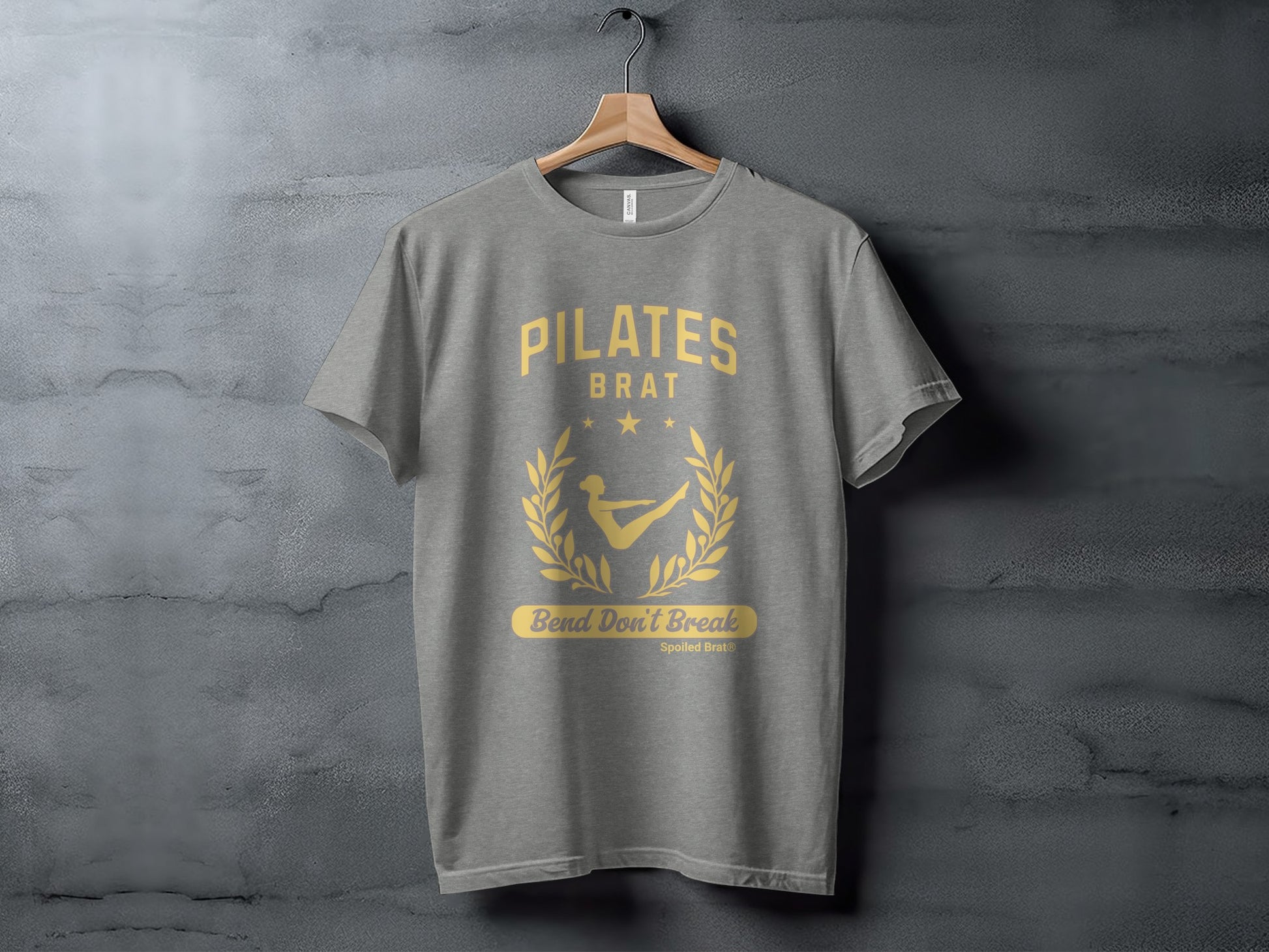 Gray t-shirt with "PILATES BRAT" and laurel wreath graphic.