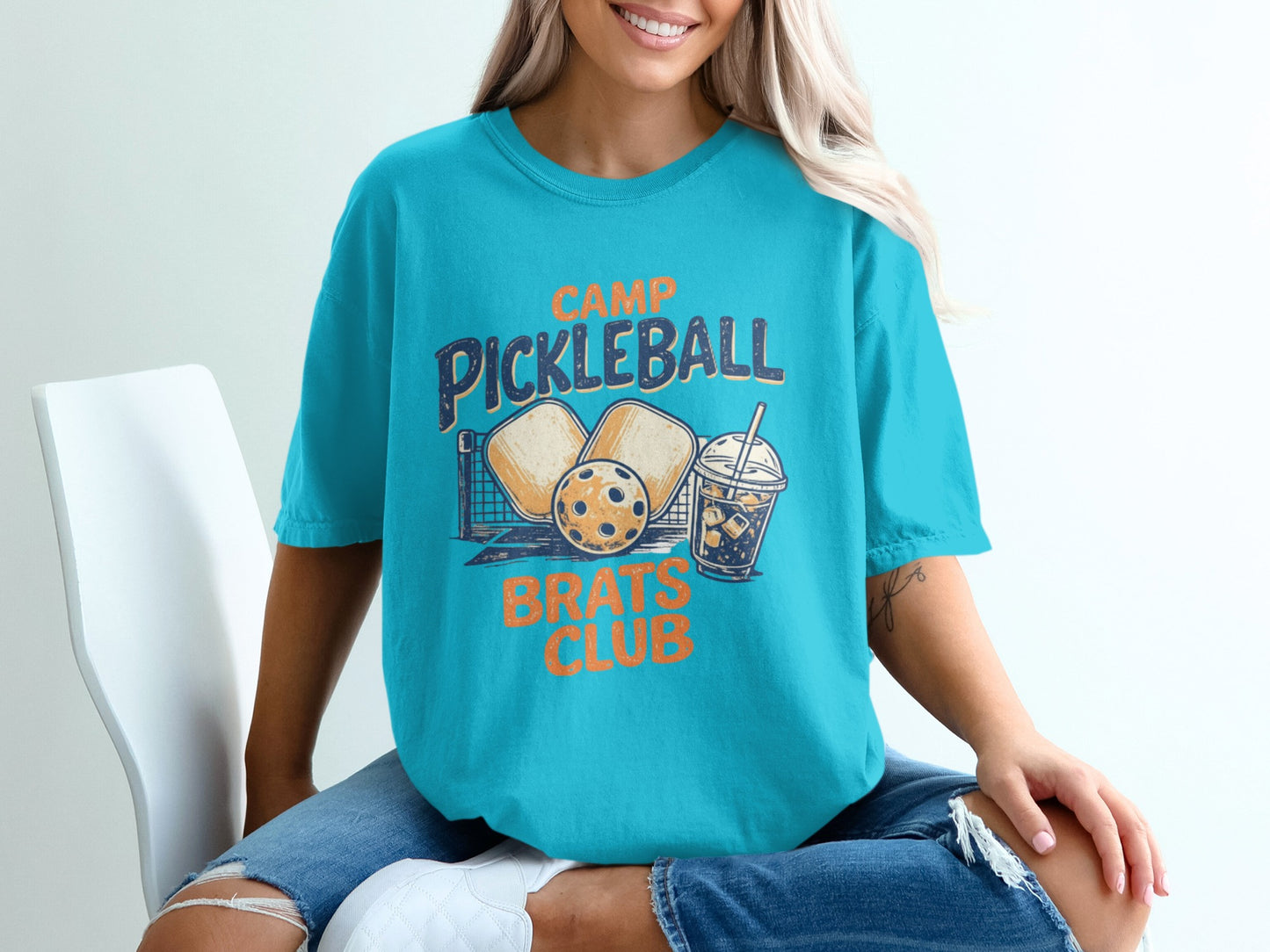 Teal t-shirt with "Camp Pickleball Brats Club" text and pickleball graphic.