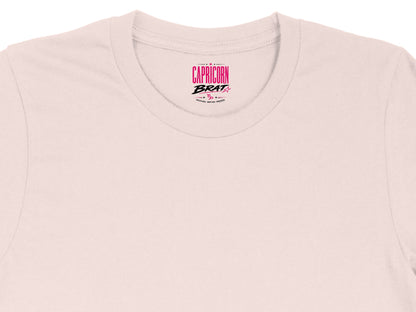 Capricorn Brat text and symbol centered on a light pink t-shirt collar.