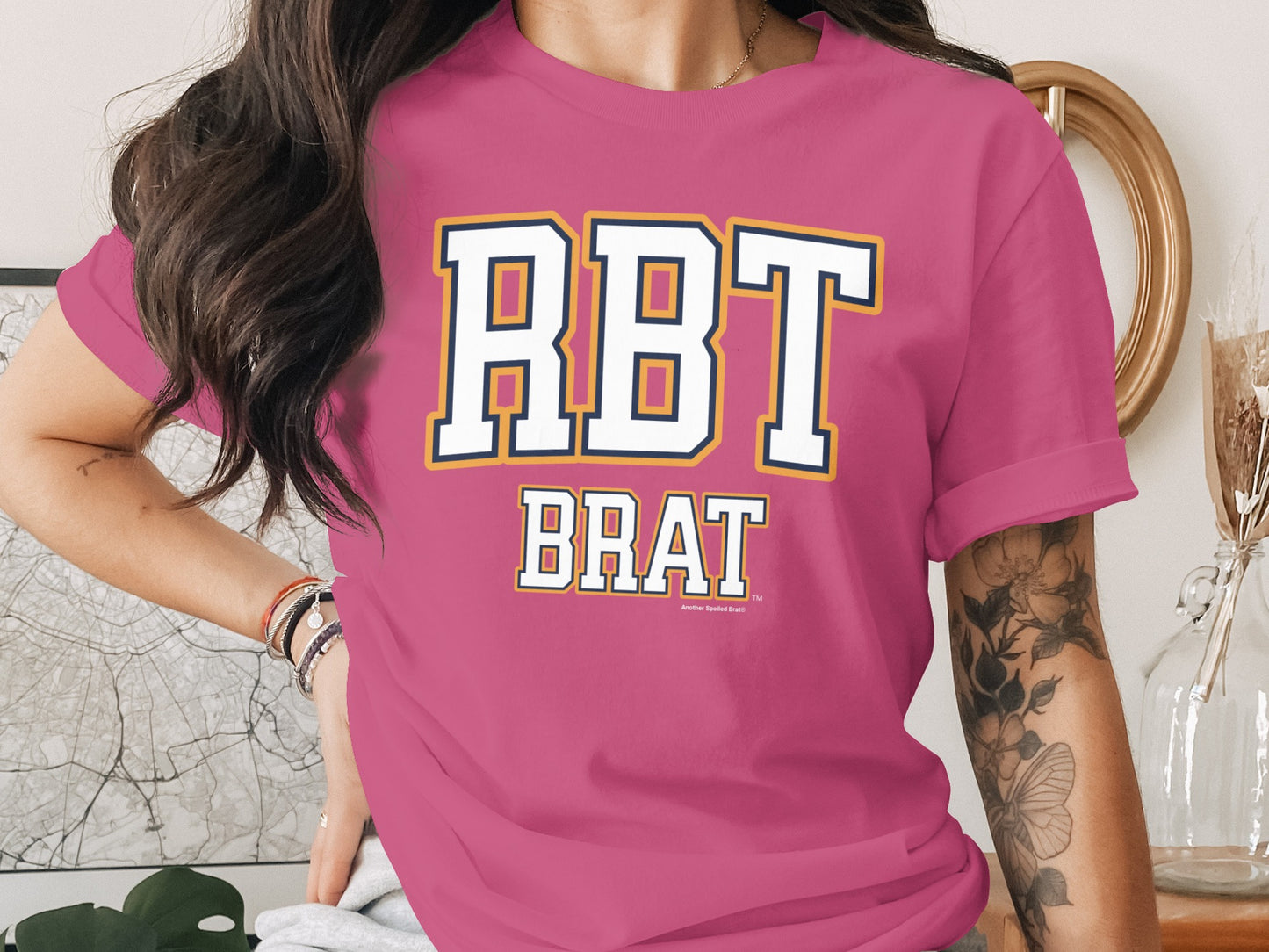 Pink t-shirt with "RBT BRAT" printed in collegiate-style lettering.