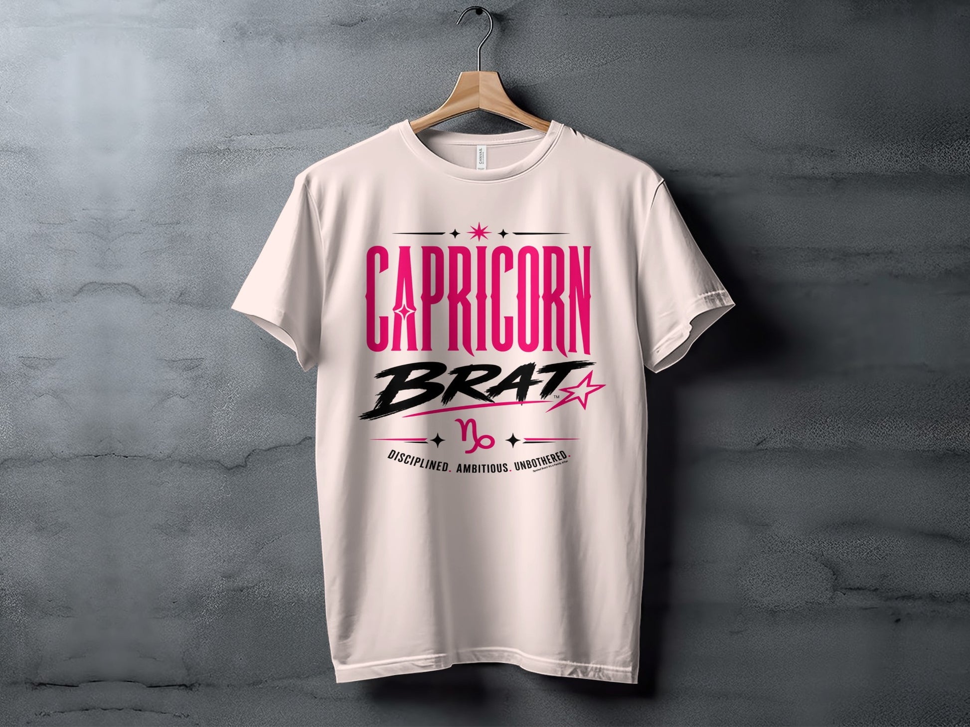 White t-shirt with pink and black "CAPRICORN BRAT" text and Capricorn symbol and traits.