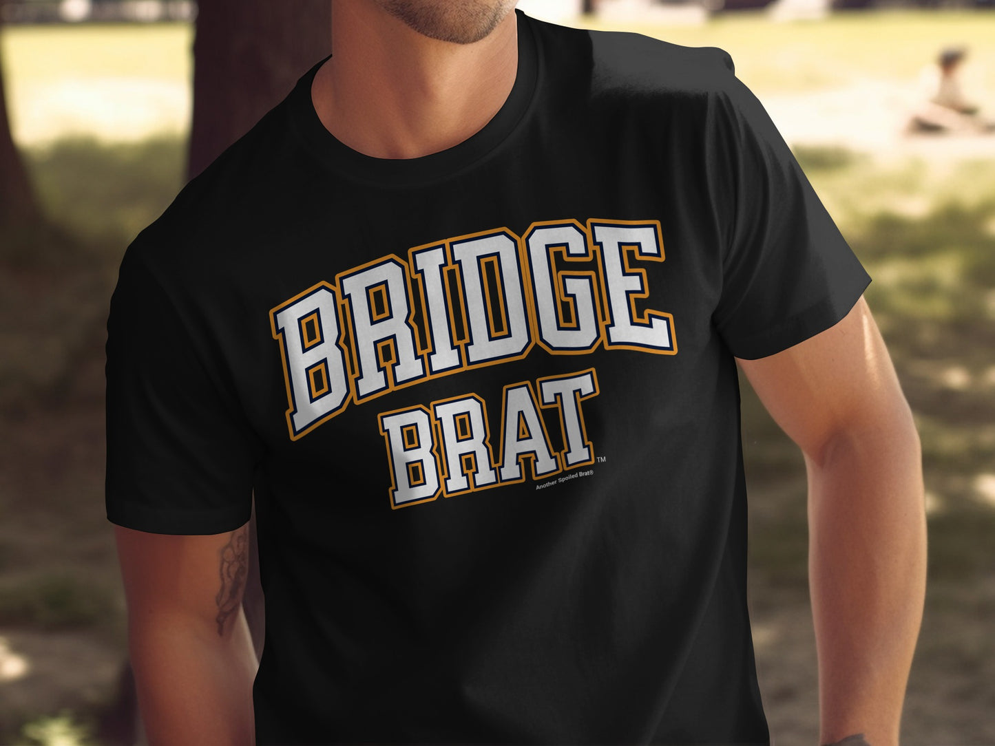 Black t-shirt with white and orange "BRIDGE BRAT" graphic.