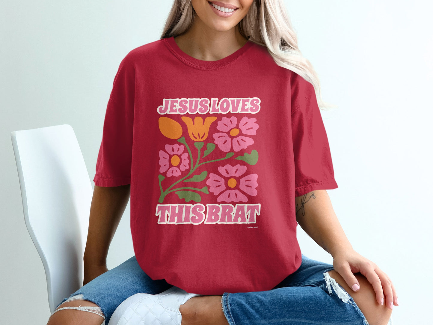 Red t-shirt with "Jesus Loves This Brat" and floral design.