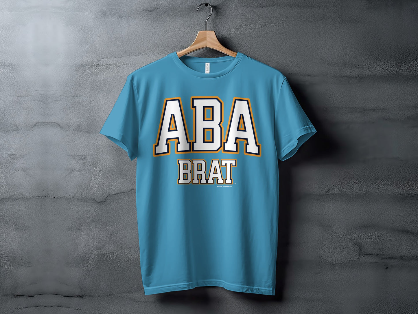 Blue t-shirt with "ABA BRAT" text in white with orange and navy trim.