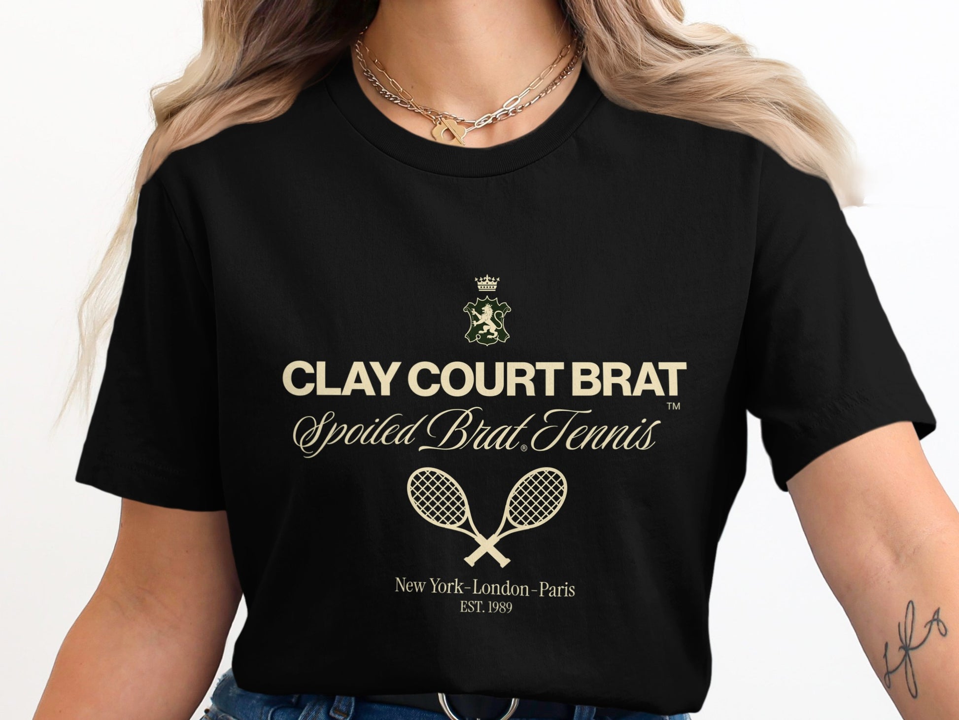 Black t-shirt with "Clay Court Brat Spoiled Brat Tennis" text and crossed racquets.