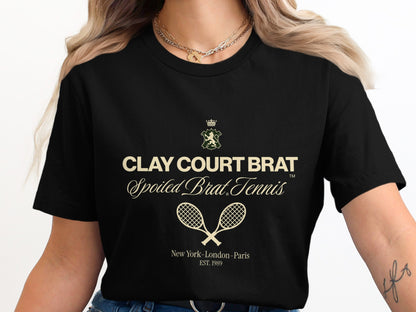 Black t-shirt with "Clay Court Brat Spoiled Brat Tennis" text and crossed racquets.